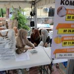 Petugas di Pasar Murah sedang memeriksa data dan melayani pembeli. foto ; Hotly/Digdata.id